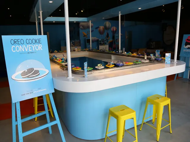 The Oreo Cookie Conveyor: a curved blue counter with yellow stools and cookies travelling on a belt