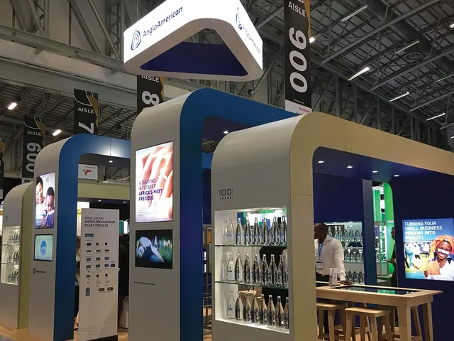 An Anglo American exhibition stand with curved blue-and-white portals and backlit displays