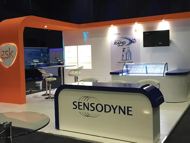 A GSK stand with an orange arched canopy over a navy Sensodyne reception counter
