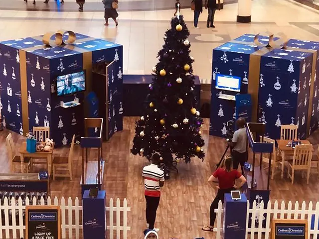A Cadbury Christmas mall activation with giant purple gift boxes, a Christmas tree and a picket fence