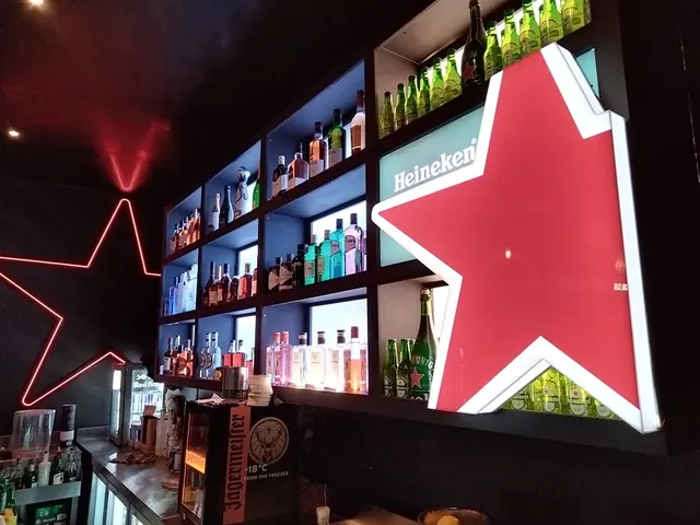 A Heineken bar with a giant illuminated red star and backlit shelves of bottles