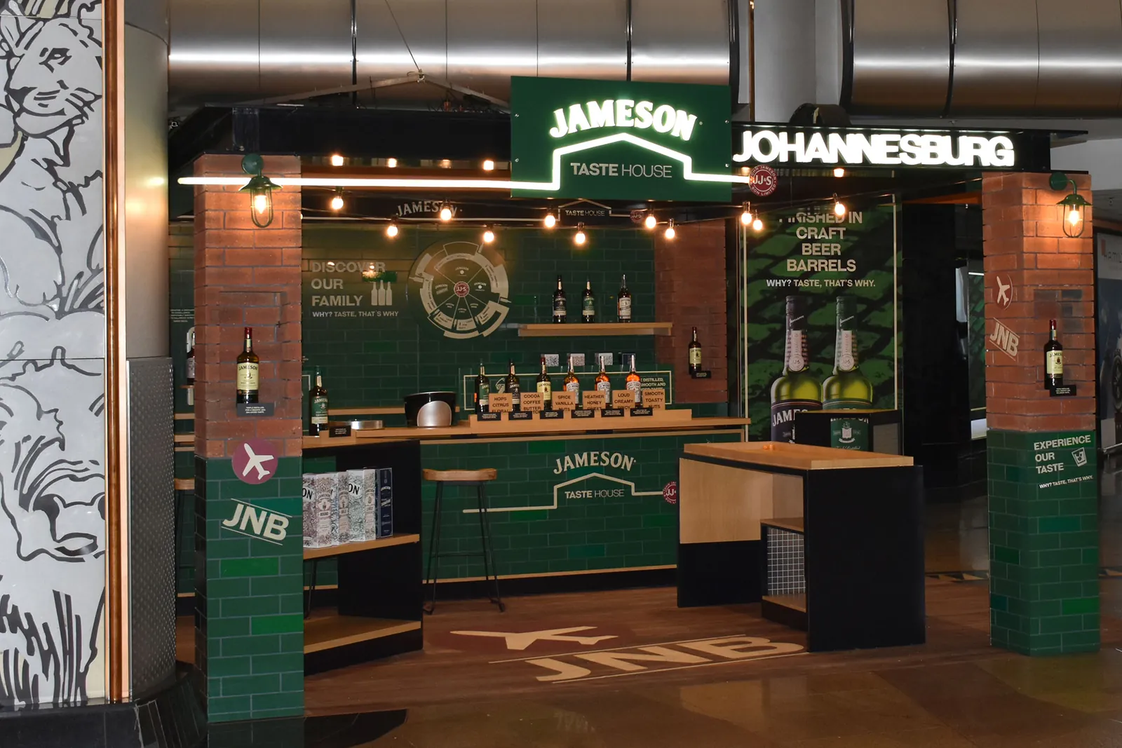 The Jameson Taste House in Johannesburg: green-tiled pillars, a long bar and a lit Jameson sign