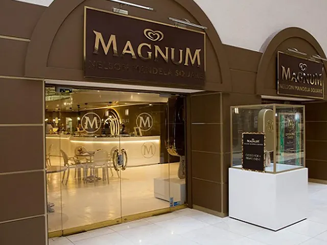 The Magnum store front with glass doors, gold lettering and a lit display case