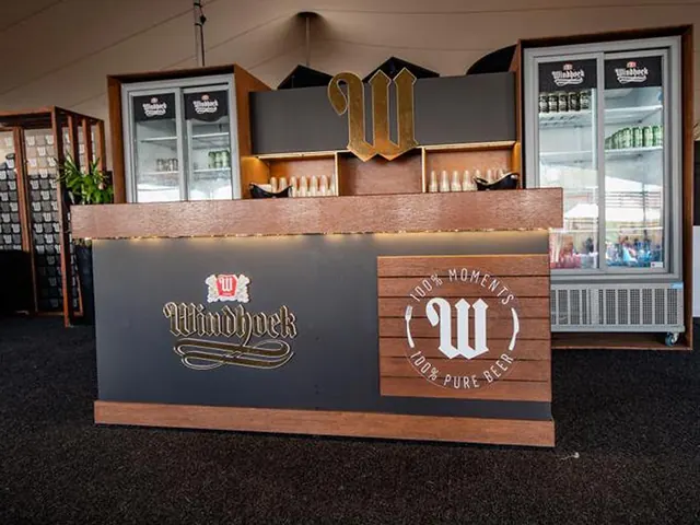 A Windhoek bar counter with timber cladding, the W emblem and branded fridges behind